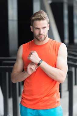 Sporcu ile pedometre becerikli alet Stadyumu'nda eğitim. Spor araç konsepti. Adam atlet Spor donatımı, kentsel arka plan ile sıkı yüzünde. Kıl fitness izci veya pedometer ile sporcu