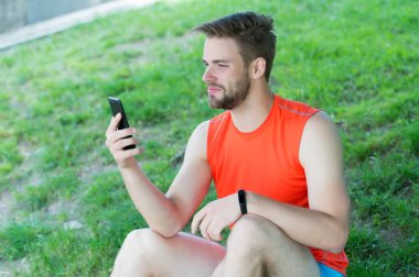 Spor araç konsepti. Atlet fitness izci veya adım sayar. Adam atlet fitness İzleyicisi ile akıllı telefon app, Doğa arka plan kurma meşgul yüz. Sporcu pedometre gadget ile eğitim