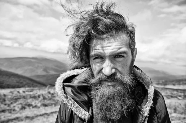 Adam acımasız sakallı görünümü ile acımasız tıraşsız adam düzensiz görünüyor. Hipster sakallı sıkı yüzündeki vahşice yürüyüş sırasında görünüyor. erkeklik kavramı. Adam uzun sakal ve bıyık giyer ceket ile