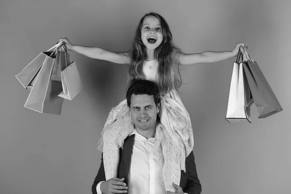 Shopping family. Girl and man with cheerful faces hold shopping bag