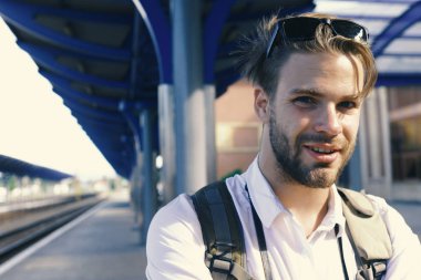 Seyahat kavramı. Gülen yüz ve sırt çantası ile turist. Platformda genç adam