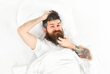 Man with itchy face wake up, lay on bed, scratching clipart