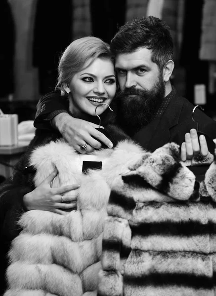 Couple in love. Fashion and shopping. Couple in love tries expensive sable overcoats