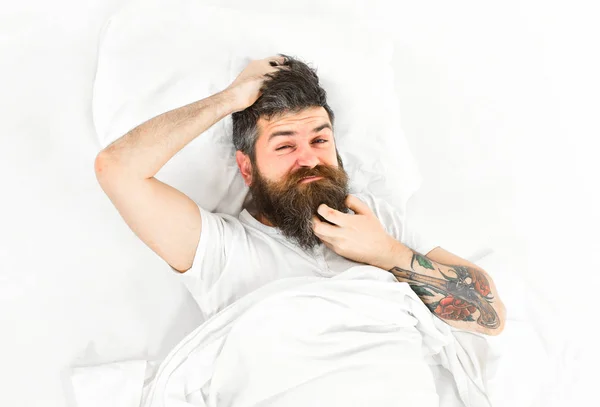 Uomo con il viso pruriginoso svegliarsi, sdraiarsi sul letto, graffiare — Foto Stock