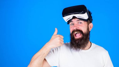 Mutlu yüz başparmak gösterilmesini uzun sakallı adam. Sakallı adam heyecanlı bakışla Vr kulaklık, dijital ilerleme kavramı, yeni modeli sınama. Üzerinde mavi arka plan izole trendy sakallı hippi