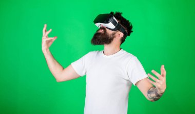 Güç kavramı. Hipster yüz eller güçlü iken yetiştirme bağırarak üzerinde etkileşim içinde sanal gerçeklik. Adam kafa monte ekran ile etkileşim Vr. erkekte Vr gözlük, yeşil arka planda sakallı