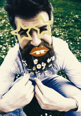 İyi günler. Hipster neşeli yüzündeki sakallı yıldız ile poz gözlük ve dudak şeklinde. Adam güzel sakal daisy çiçeklerle benziyor. Photosession kavramı