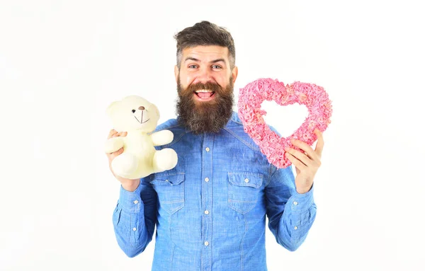 Hipster con corazón rosa, oso de peluche y cara alegre feliz . —  Fotos de Stock