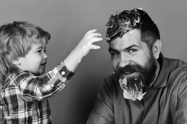 Limpieza y limpieza. Hombre con barba y niño sonriente juega con jabón suds . — Foto de Stock