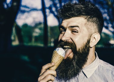 Komik turist. Uzun sakallı dondurma yalıyor, yakın çekim. Dondurma külahı sakallı adam. Sakal ve bıyık mutlu yüz yiyor defocused dondurma, Doğa arka plan üzerinde olan adam. Tüyler ürpertici kavramı