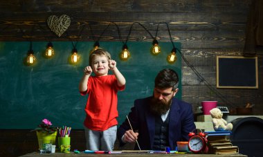 Baba Çocuk oynarken boyama. Küçük çocuk yumruklarını meşgul babasının yanında duran gösterilen. Konsantre baba ve oynak çocuk