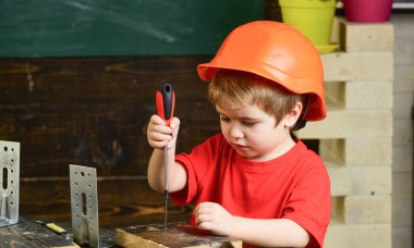 Turuncu baret veya kask, çalışma odası arka plan çocuk evlat. Çocuk Oluşturucusu'nu veya repairer oynamak, aletlerle çalışırız. Çocukluk kavramı. Gelecekteki kariyer mimarisi veya bina hakkında rüya çocuk