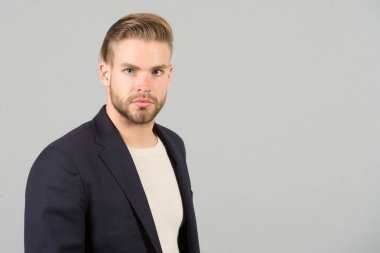 Adam çekici bakımlı işadamı sakallı. Sakal tıraşsız adam adam yakışıklı bakımlı formal giyim görünüyor. Moda kavramı. İşadamı sıkı sakin yüz Yöneticisi, gri arka plan sakallı