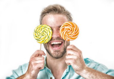 Adam büyük lolipop gözler gözlük tutar. Adam kıl ile tatlılar seviyor. Tatlıya kavramı. Beyaz arka plan üzerinde izole elinde iki dev renkli lolipop adam yüzü gülen üzerinde tutar