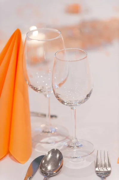 Weingläser und gefaltete Serviette tishue auf Restauranttisch mit weißer Tischdecke bedeckt. Besteck und Weingläser im Restaurant aus nächster Nähe. Restaurantkonzept — Stockfoto