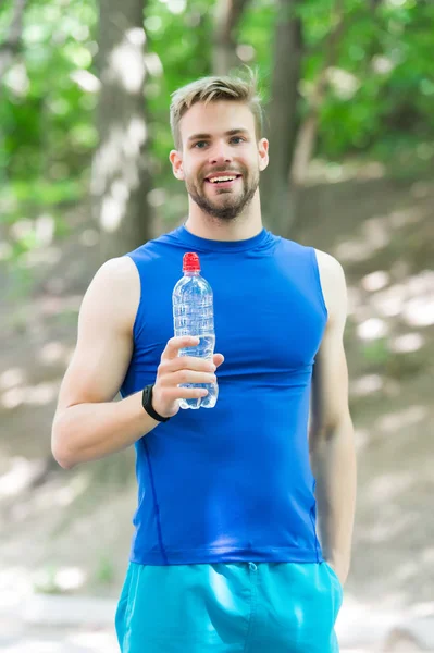 Atlet güneşli Park eğitimden sonra su içer. Adam atletik çekici görünüm su şişesi tutar. Adam atlet spor giysiler açık eğitim. Spor ve sağlıklı yaşam konsepti — Stok fotoğraf