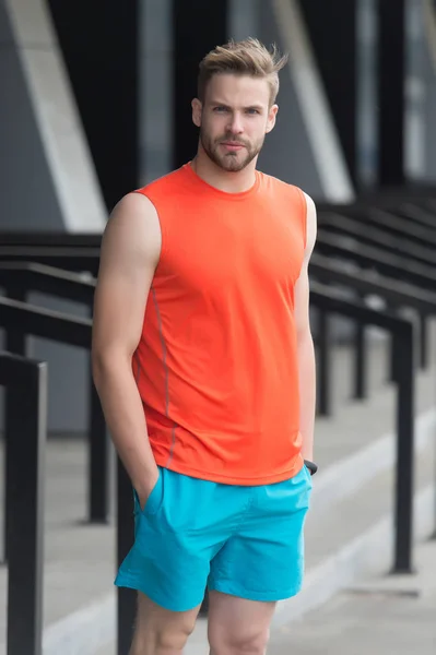 Man with bristle on serious face in sporty wear, urban background. Sport fashion concept. Guy bearded and attractive cares about appearance. Man with beard or unshaven guy in stylish sport clothes — Stock Photo, Image