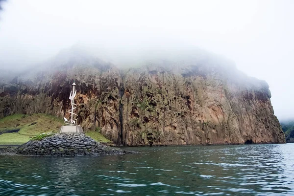 Costa rocosa del mar en el cielo brumoso en Heimaey, iceland. Formación de montaña a lo largo de la costa. Mar en el paisaje de montaña. Naturaleza con buen concepto ecológico y medioambiental —  Fotos de Stock