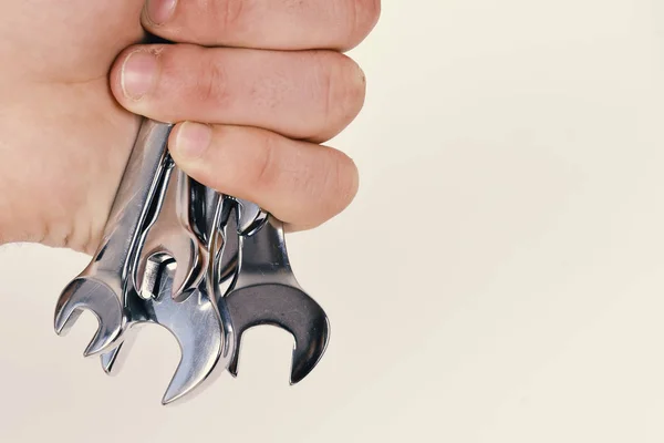 Mechanic keys. Set of wrench tools in male hand isolated on white background, copy space. Maintenance and repairing concept. Spanner equipment made of metal — Stock Photo, Image