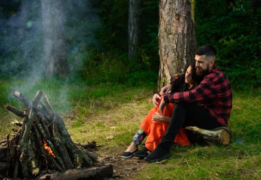 Kadınlı bir adam sarılıyor ve şenlik ateşinin yanında ısınıyor..