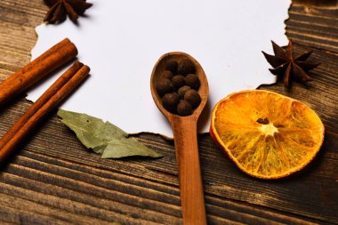 Baharatlar, beyaz kağıt mutfak otlar yatıyordu. Tarçın, kurutulmuş portakal ve anasonu lay boş kağıt, tarifi, çevresinde yer kopyalayın. Ahşap arka plan üzerinde kağıt parçası. Mutfak tarifi kavramı