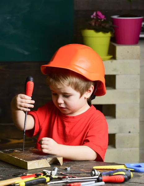소년은 작성기 또는 자 플레이, 도구를 사용. 주황색 모자 또는 헬멧, 연구 방 배경에서 소년 아이. 어린 시절 개념입니다. 어린이 건축 또는 건물에서 미래의 직업에 대 한 꿈 — 스톡 사진