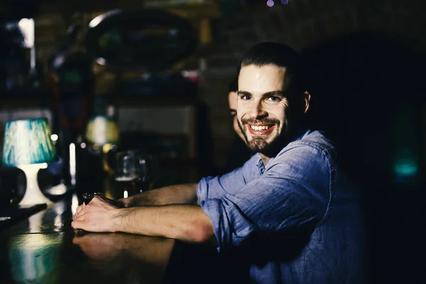 Homem relaxando no bar. Cara com tiro ou licor sentado no balcão do bar . — Fotografia de Stock