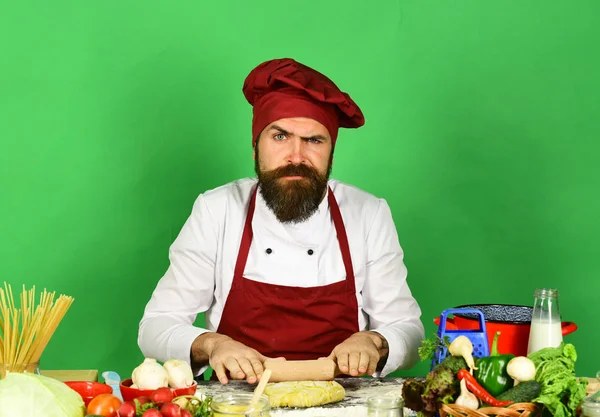 Professional cuisine concept. Chef with pasta, vegetables and dough