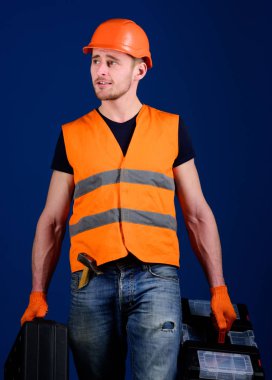Tamirci, tamirci rüya gibi yüzüne gider ve profesyonel ekipman ile çanta taşır. Kask, kask içinde adam araç kutusu ve araç, mavi arka plan ile bavul tutar. Profesyonel tamirci kavramı