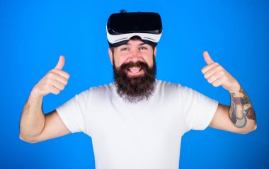 Sakal ve sanal gerçeklik deneyimi zevk neşeli yüzü olan adam. Şık sakal ve büyük gülümseme mutlu hakkında yeni Vr kulaklık ile hippi. Sakallı adam üzerinde izole mavi arka plan Yaşasın gösterilen