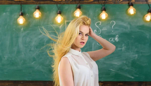 Sexy leraar concept. Vrouw met lange haren in witte blouse staat in de klas. Leraar met lang blond haar zwaaien ziet er sexy uit. De strenge leraar Lady op dromerige gezicht staat voor schoolbord — Stockfoto