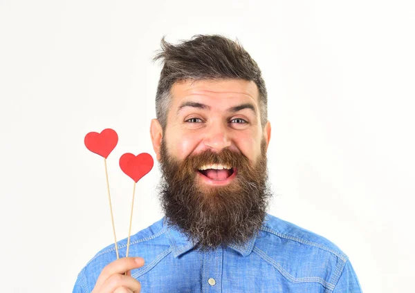 Hombre barbudo guapo sosteniendo el símbolo rojo del corazón y sonriendo —  Fotos de Stock