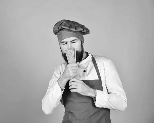 Кухар з прихованим мрійливим обличчям тримає сухі макарони — стокове фото