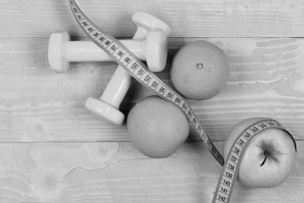 health and gym concept, dumbbells weight with measuring tape ,fruit