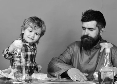 çöp ev temizlik ürünleri. Baba ile oğlu ve yeşil zemin üzerine temizlik malzemeleri.