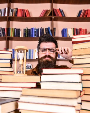 Zaman akışı kavramı. Öğretmen ya da sakal Kitaplığı'nda eğitim ile öğrenci. Dostum, bilim adamı bardaklarda kum saati görünüyor. Adam ciddi yüz izlerken zaman raflardan, arka planda gidiyor