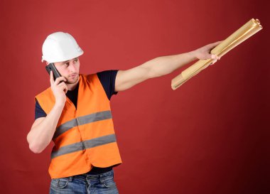 Müzakere kavramı. Dostum, kask içinde mimar inşaat telefon, kırmızı zemin üzerine denetlemektedir. Mühendis, mimar, Oluşturucu meşgul yüzündeki konuşuyor Smartphone cep telefonu ile ayrı tutma planları, kopya alanı ise