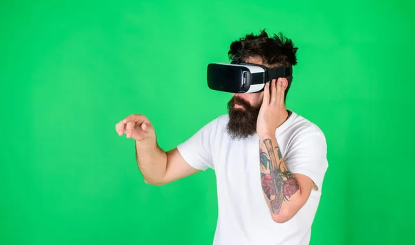 Man performing musical show in virtual reality simulation game. Bearded man with tattoo wearing VR headset. Man with hipster beard using digital touch screen interface, virtual reality concept