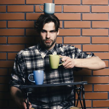 Duvarda bardakları tutan yakışıklı adam.