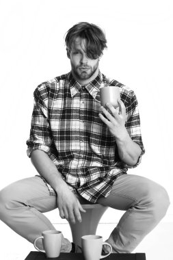 Beyaz arka planda izole edilmiş bardakları tutan yakışıklı adam.