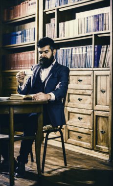 Aristokrat düşünceli yüz okuma kitabı. Eski kafalı adam bardak tutar.