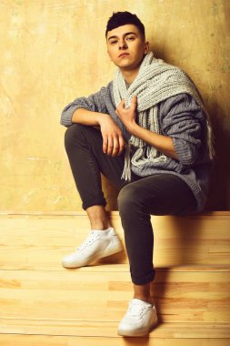 Gri süveter ve eşarplı yakışıklı genç adam.