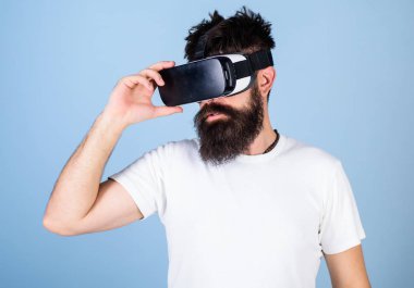 Vr gözlük, açık mavi renkli sakallı adam. Hipster ciddi bir yüz üzerinde sanal gerçeklik keşfetmek için modern Gadget'ı kullanın. VR gadget kavramı. Adam kafa monte ekran ile etkileşim içinde sanal gerçeklik