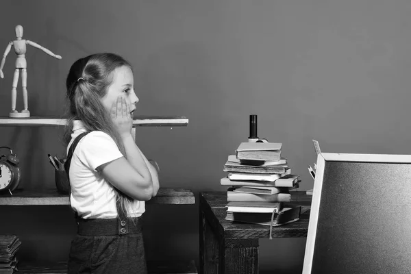 Kid and school supplies on red wall background — Stock Photo, Image