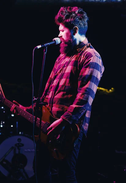 Homem com cara entusiasta segura guitarra, cantando música, tocar música , — Fotografia de Stock