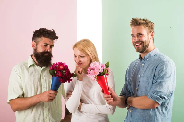 Los hombres competidores con ramos de flores tratar de conquistar chica. A la chica le gusta estar en medio de la atención. Triángulo amoroso. Mujer reflexiva tiene oportunidad de elegir pareja. Chica popular recibir muchos hombres atención — Foto de Stock