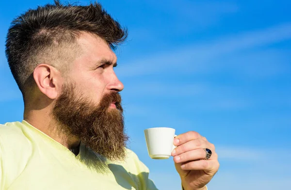 Człowiek z długą brodą wypić kawę. Koncepcja kawy dla smakoszy. Człowiek z broda i wąsy na ścisłe twarz pije kawę, tle błękitnego nieba, rozmyte. Brodaty mężczyzna z espresso kubek, pije kawę — Zdjęcie stockowe