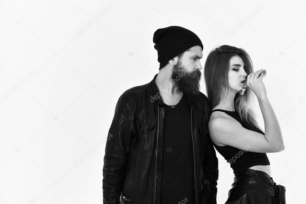 Girl and bearded man in black leather jacket and hat
