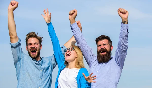 Freedom concept. Company three happy colleagues office workers enjoy freedom, sky background. Employees enjoy feeling of freedom. Men with beard in formal wear and blonde in eyeglasses finished work