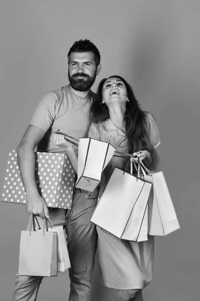 Familie winkelen. Verliefde paar houdt boodschappentassen op gele achtergrond — Stockfoto